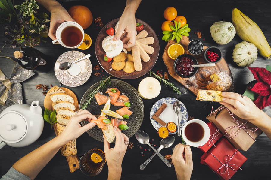 Party food on plates with hands and pot of tea
